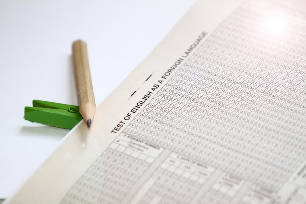 A close-up shot of an SAT test booklet with a No. 2 pencil lying on top. The focus is on the test questions and answer sheet, with a blurred background of other test-taking materials.